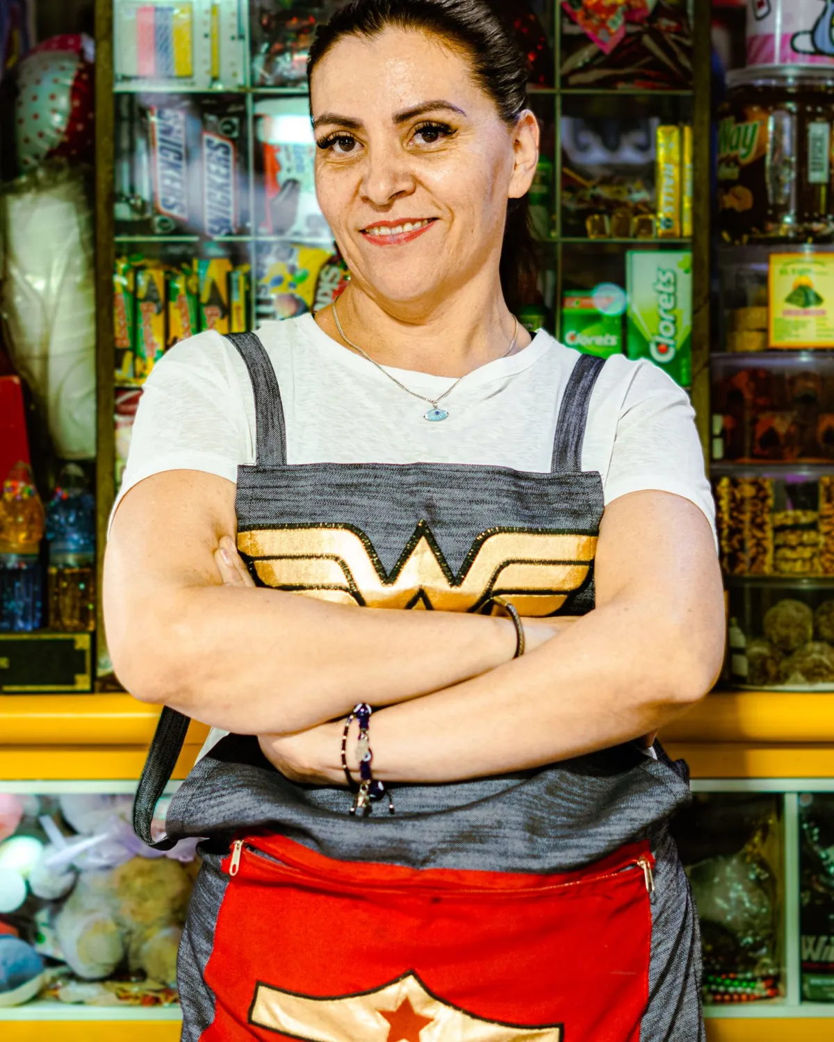 Dueña sonriente de una tienda de dulces en la Ciudad de México, frente a su mostrador