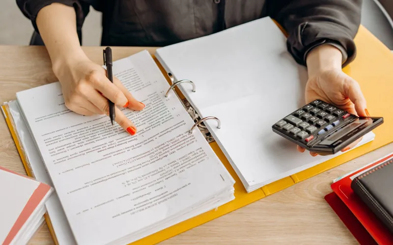 Persona revisando y firmando documentos con pluma